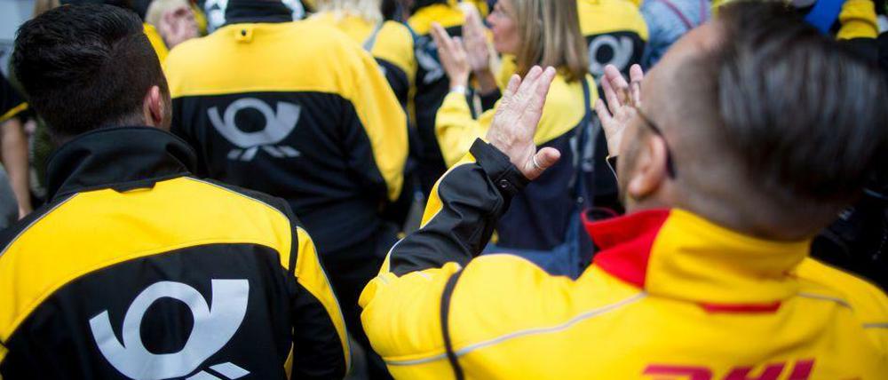 Huch, wo kommen die denn alle her? - Die einen Postmitarbeiter streiken, andere verteilen Pakete.
