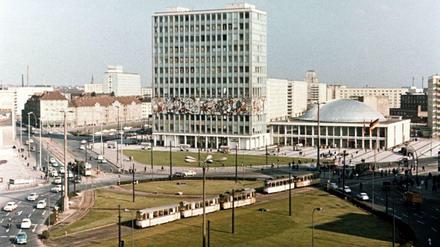 Berlin-Mitte, 1965, der Alexanderplatz vor der Umgestaltung. Die Autos rollen hier an der Konferenzhalle und vor dem Haus des Lehrers im Kreis; links ist sogar noch der Alt-Bau-Bestand an der Karl-Marx-Allee zu sehen.