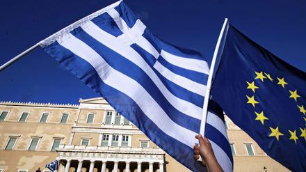 Die Fahnen Griechenlands und der EU in der Hand von Demonstranten in Athen