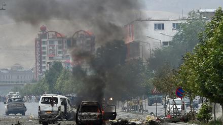 In der Nähe des von Taliban-Kämpfern attackierten Parlamentsgebäudes in Kabul steigt Qualm von zerstörten Autos auf.