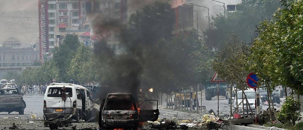 In der Nähe des von Taliban-Kämpfern attackierten Parlamentsgebäudes in Kabul steigt Qualm von zerstörten Autos auf.