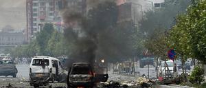 In der Nähe des von Taliban-Kämpfern attackierten Parlamentsgebäudes in Kabul steigt Qualm von zerstörten Autos auf.