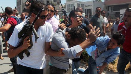 Tunesische Sicherheitskräfte führen einen Mann nach dem Attentat in Sousse ab.
