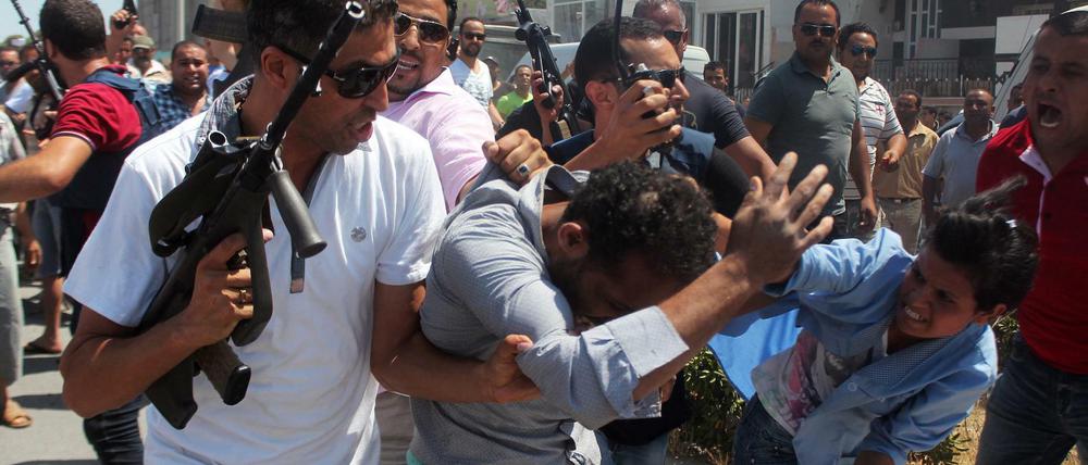 Tunesische Sicherheitskräfte führen einen Mann nach dem Attentat in Sousse ab. 