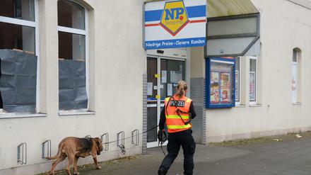 Mit einem Spürhund sucht eine Polizeibeamtin am 05.12.2014 vor einem Supermarkt in Hannover nach Spuren. Hier hatte ein Räuber einen Kunden erschossen, der ihn aufhalten wollte. Nun hat die Polizei den Mann finden und festnehmen können.