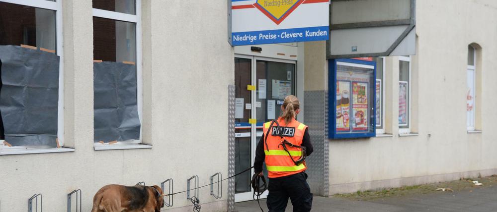 Mit einem Spürhund sucht eine Polizeibeamtin am 05.12.2014 vor einem Supermarkt in Hannover nach Spuren. Hier hatte ein Räuber einen Kunden erschossen, der ihn aufhalten wollte. Nun hat die Polizei den Mann finden und festnehmen können.