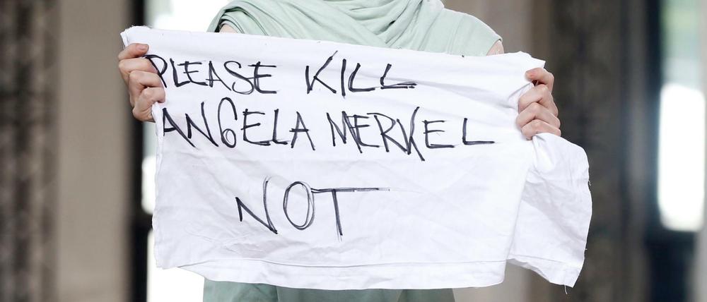 "Please kill Angela Merkel not", steht auf einem Stoff-Banner des Models Jera Diarc auf den Pariser Männermodenschauen im Juni 2015.