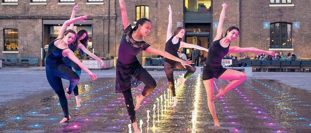Immer im Takt: Eine Gruppe von Freundinnen feiert Geburtstag in den Wasserspielen am Granary Square. Im Hintergrund der renovierte Getreidespeicher.