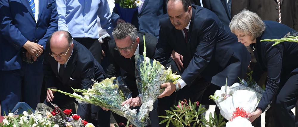 Bundesinnenminister Thomas de Maiziere (2.v.l.), der tunesische Innenminister Mohamed Najem Gharsalli (2.v.r.) und die britische Innenministerin Theresa May legten am Montag am Strand vor dem Imperial Marhaba Hotel in Sousse (Tunesien) Blumen nieder. 