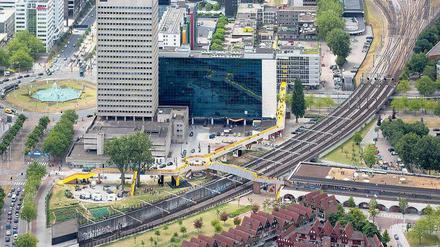 Das gelbe Band. Die „Luchtsingel“ (Luftgracht) verbindet den entstehenden Park Pompenburg (links) und den alten Bahnhof Hofplein (rechts) mit dem Stadtzentrum quer durch den Schieblock (Hintergrund) zum neuen Hauptbahnhof. Der Kreisel markiert das alte Stadtzentrum Rotterdams und korrespondiert mit dem Kreisverkehr Hofplein links im Bild.