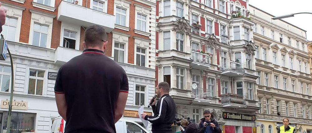 Der Berliner NPD-Chef Sebastian Schmidtke (mit Mikrofon) spricht vor dem berüchtigten Haus (hinter dem Mann mit der Kamera) in der Grunewaldstraße.