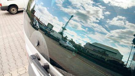 Hallo Nachbar! Das ICC und der Funkturm spiegeln sich in der Scheibe eines Autos. Der Wagen steht auf dem Parkplatz, auf dem seit Jahren ein Hotel geplant ist.
