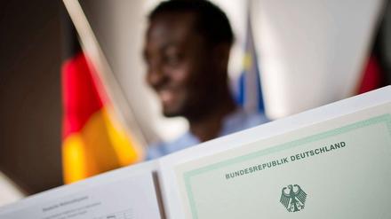 Einbürgerungsfeier. Nicht immer ist die Einbürgerung mit solch einem Zeremoniell wie hier in Hannover verbunden, wo auch dieser Mann aus Kamerun seine Urkunde erhielt.