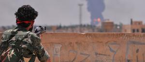Ein kurdischer YPG-Kämpfer blickt auf die ebenfalls umkämpfte Stadt Hasakeh in Nordsyrien.