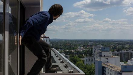Gefährlich sieht es aus, fast lebensmüde. Doch für R. gehören solche Situationen wie hier an einem Hochhaus in der Gropiusstadt in Neukölln zum Arbeitsalltag. Rooftopping im Waschbärenstil nennt er seine Kletterei.