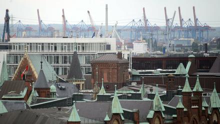 Blick auf die Dächer der Hamburger Speicherstadt (vorne) und die Kräne der Containerterminals