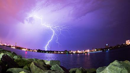 Blitze zucken am Sonntag über dem Hafen von Rostock während eines Gewitters über den Himmel.