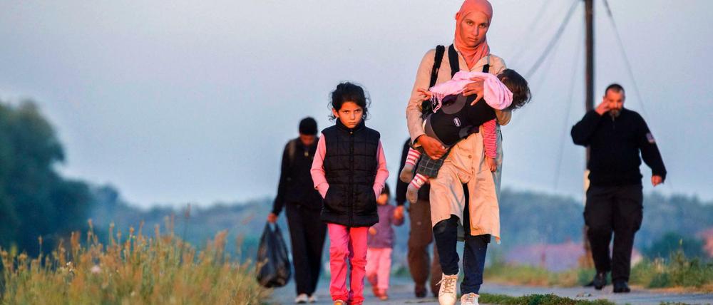 Ungarische Polizeibeamte eskortieren diese nahe der Stadt Szeged aufgegriffenen Flüchtlinge. Ungarn schottet sich immer mehr gegen den Zustrom von Flüchtlingen ab. 