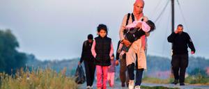 Ungarische Polizeibeamte eskortieren diese nahe der Stadt Szeged aufgegriffenen Flüchtlinge. Ungarn schottet sich immer mehr gegen den Zustrom von Flüchtlingen ab. 