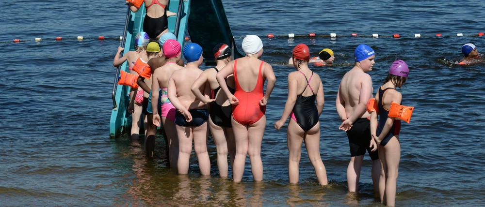 Kinder einer Potsdamer Schule klettern am im Strandbad Babelsberg in Potsdam (Brandenburg) bei sommerlichem Wetter auf die Wasserrutsche. 