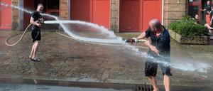 Wet T-Shirt Contest. Schön, wenn sich Angenehmes mit Nützlichem verbindet wie für diese Männer von der Feuerwache in der Oderberger Straße in Prenzlauer Berg. Eine Übung zur Wasserversorgung über lange Strecken gab Gelegenheit zur Abkühlung.