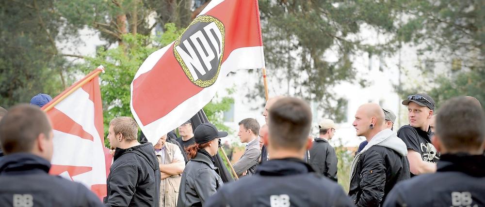Mitglieder der NPD schwenken am 01.05.2014 an der brandenburgischen Aufnahmeeinrichtung für Asylbewerber in Eisenhüttenstadt (Brandenburg) ihre Fahnen. 