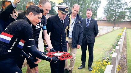 Abseits des Pelotons. Der britische Fahrer Christopher Froome (2. v.l.) legt Blumen an einem Gedenkort nieder. 