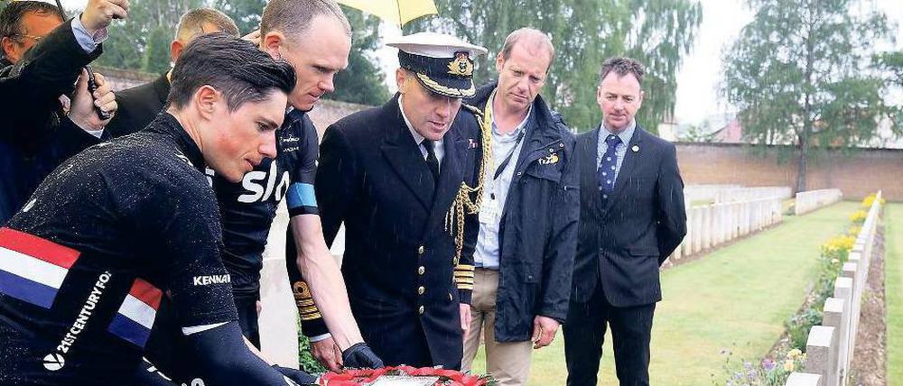 Abseits des Pelotons. Der britische Fahrer Christopher Froome (2. v.l.) legt Blumen an einem Gedenkort nieder. 
