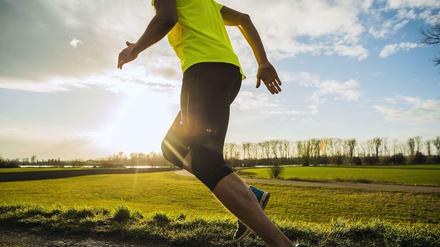 Er hat Abnehmen nicht nötig. Oberkörper und Beine eines schlanken Sportlers beim Joggen auf dem Feldweg.