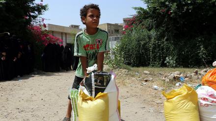 Schwierige Nahrungssuche. Ein kleiner Junge trägt Lebensmittel nach Hause, die von einer Hilfsorganisation im jemenitischen Taiz angeliefert wurden. 