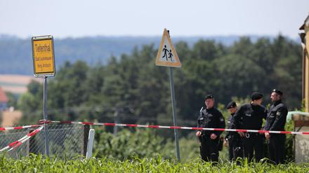 Polizeibeamte stehen am Freitag an einem Tatort in Tiefenthal-Leutershausen bei Ansbach (Bayern). Ein Amokläufer hat dort mindestens zwei Menschen getötet. Die Polizei konnte den mutmaßlichen Täter kurz darauf festnehmen.