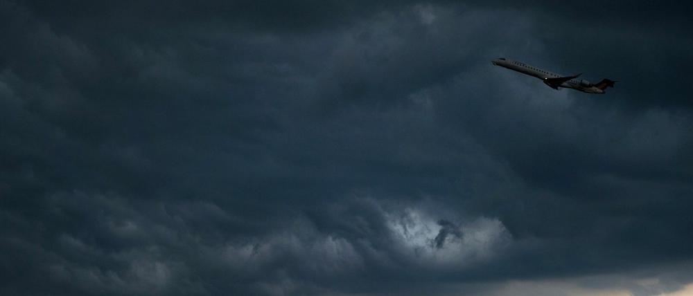 Ein Flugzeug vor dunklen Gewitter-Wolken (Archivbild).