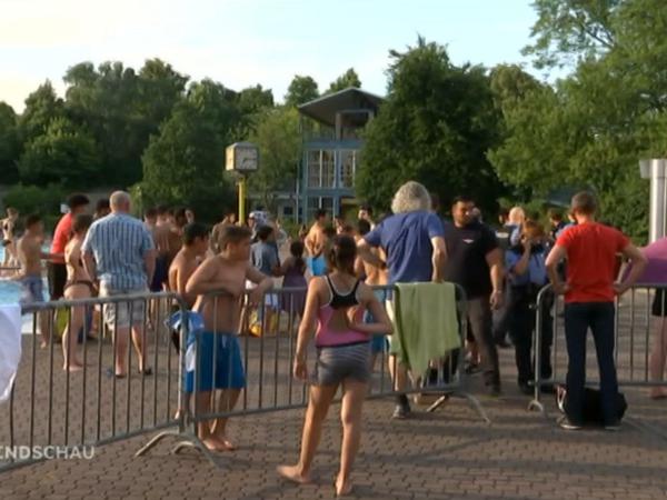 Zwischen Drehteam und Badegästen wurden Absperrungen errichtet. Polizeibeamte versuchen, die Lage im Columbiabad unter Kontrolle zu halten.