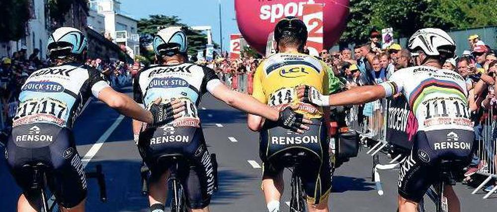Sanft hinausgeleitet. Tony Martin wird von seinen Teamkollegen eskortiert. Sie dürfen weiterfahren, für ihn ist die Tour beendet. 