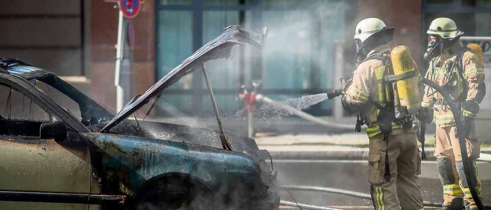 Einsatzkräfte der Feuerwehr löschen ein brennendes Taxi in der Dorotheenstraße im Regierungsviertel in Berlin. Der Polizei zufolge war ein technischer Defekt die Brandursache. Der Taxifahrer wurde bei dem Feuer nicht verletzt. 
