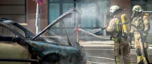 Einsatzkräfte der Feuerwehr löschen ein brennendes Taxi in der Dorotheenstraße im Regierungsviertel in Berlin. Der Polizei zufolge war ein technischer Defekt die Brandursache. Der Taxifahrer wurde bei dem Feuer nicht verletzt. 