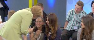 Angela Merkel spricht mit der weinenden Reem, die den Schulbesuch der Kanzlerin in Rostock nutzte, um auf ihr Schicksal aufmerksam zu machen.