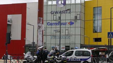 Französische Polizisten vor dem Einkaufszentrum "Qwartz" im Pariser Vorort Villeneuve-la-Garenne. Bewaffnete haben hier am Montag eine Primark-Filiale überfallen. 