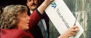 Die scheidende Treuhand-Präsidentin Birgit Breuel entfernt am 30.12.1994 eigenhändig mit einem Schraubenzieher das Firmenschild am Eingang der Treuhandanstalt in Berlin. Auf die Treuhand wurde viel eingedroschen. Doch das war gewollt, wie ein neues Buch des Hamburger Autor Dirk Laabs über das wohl dunkelste Kapitel der Wiedereinigung zeigt. Die Superbehörde diente Bundesregierung und Wirtschaftskonzernen als Sündenbock beim Ausverkauf der DDR. 