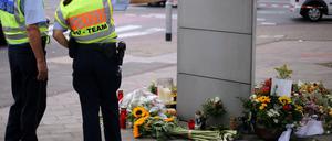 Polizisten stehen am Mittwoch in Köln an einer Unfallstelle, an der Blumen und Kerzen liegen. Bei einem illegalen Autorennen an der Stelle ist am Freitag ein Radfhrer möglicherweise angefahren worden.