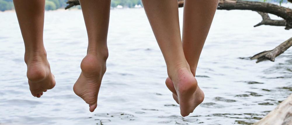 Nichts wie raus: Zwei Kinder lassen am Wannsee die Beine baumeln.