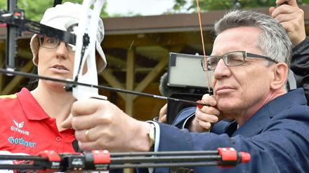 Thomas de Maizière mit Pfeil und Bogen: Der Bundesinnenminister will Deutschlands Spitzensportler mit seiner Forderung nach mehr Medaillen Beine machen.