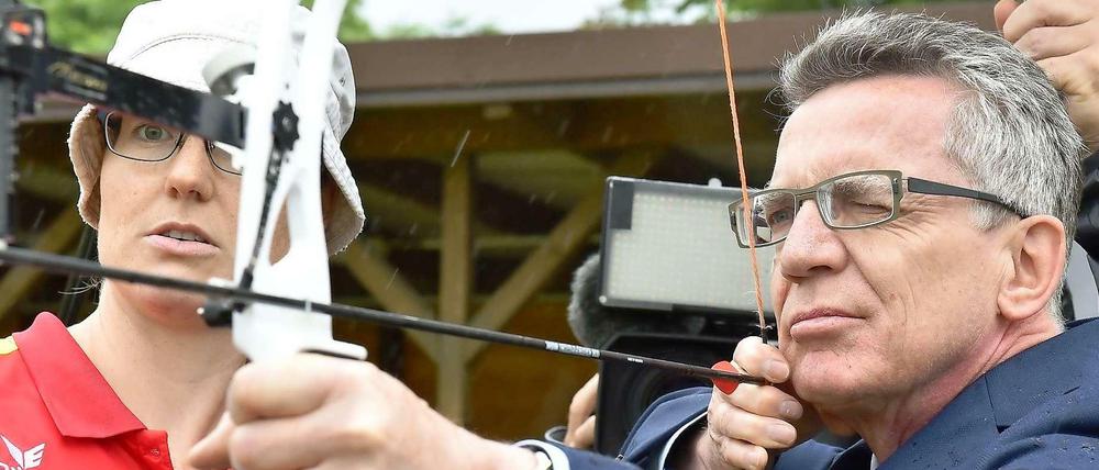 Thomas de Maizière mit Pfeil und Bogen: Der Bundesinnenminister will Deutschlands Spitzensportler mit seiner Forderung nach mehr Medaillen Beine machen.