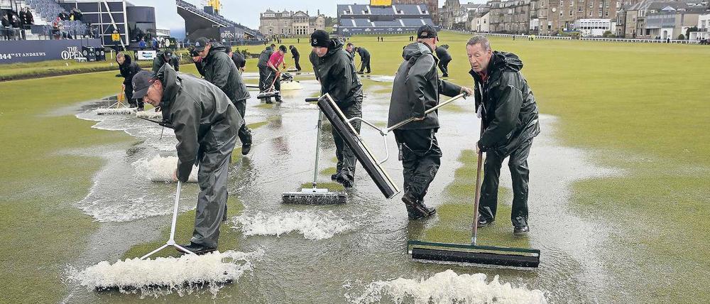 Läuft doch. Nach heftigen Regenfällen am zweiten Turniertag in Schottland entfernen Groundkeeper das Wasser vom Old Course in St. Andrews.
