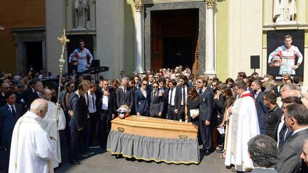 Auf dem Sarg von Jules Bianchi liegt bunt schimmernd sein alter Formel-1-Helm, dahinter haben die Trauernden Aufstellung vor der Cathédrale Sainte-Réparate genommen. 