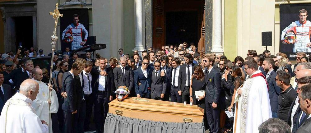 Auf dem Sarg von Jules Bianchi liegt bunt schimmernd sein alter Formel-1-Helm, dahinter haben die Trauernden Aufstellung vor der Cathédrale Sainte-Réparate genommen.