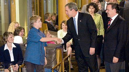Mit Handschlag begrüßt US-Präsident George Bush (M) am Mittwochabend (22.05.2002) jeden Gast des Restaurants "Tucher" in Berlin. Bush kam direkt nach seiner Ankunft in der Hauptstadt mit Bundeskanzler Gerhard Schröder (SPD, r) in die Gaststätte am Brandenburger Tor zum Abendessen.