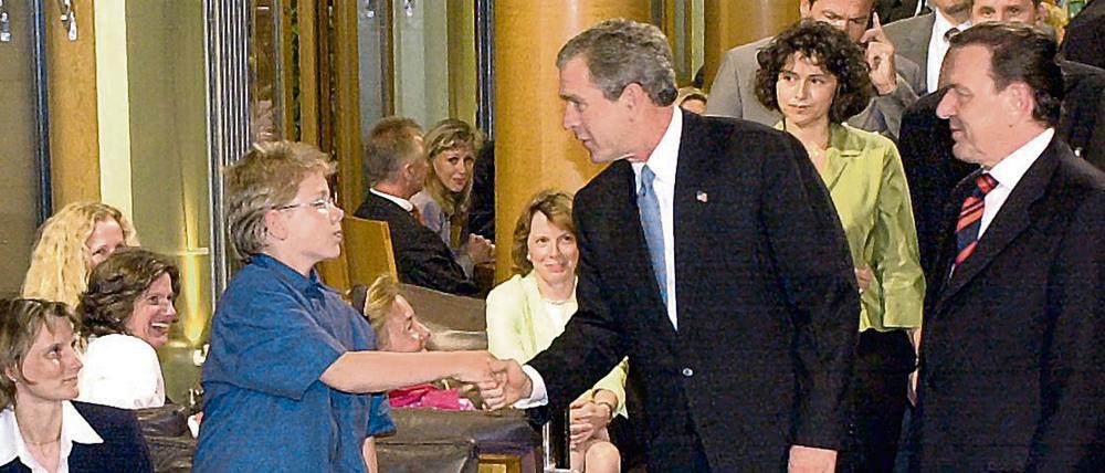 Mit Handschlag begrüßt US-Präsident George Bush (M) am Mittwochabend (22.05.2002) jeden Gast des Restaurants "Tucher" in Berlin. Bush kam direkt nach seiner Ankunft in der Hauptstadt mit Bundeskanzler Gerhard Schröder (SPD, r) in die Gaststätte am Brandenburger Tor zum Abendessen. 