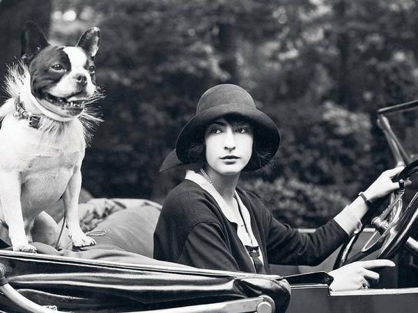 Das Bild zeigt eine Berlinerin im Jahr 1924 mit ihrer Französischen Bulldogge im Cabriolet.