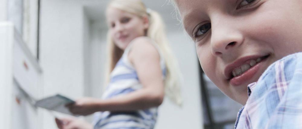 Kinder tragen das Telefonbuch aus. Laut einer Umfrage hat jedes Zweite Kind einen Aushilfsjob.